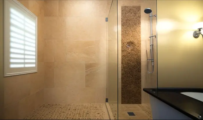 Applying a vinegar and water solution to mold stains on travertine shower