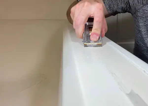 Scrubbing adhesive stain from a fiberglass tub