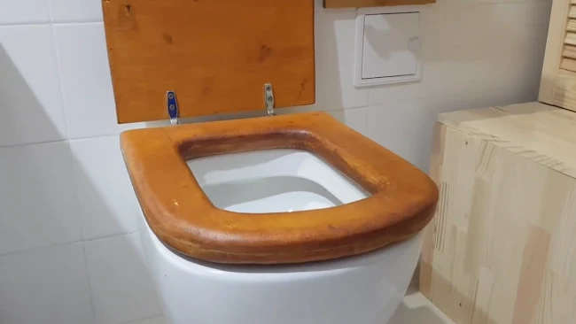 What is the Reason for the Yellow Underside of the Wooden Toilet Seat
