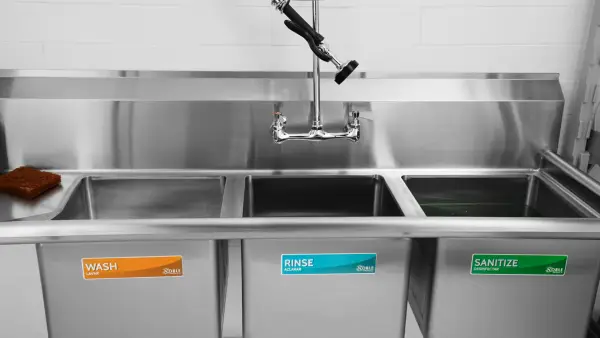 What materials are suitable for a three-compartment sink in a home kitchen